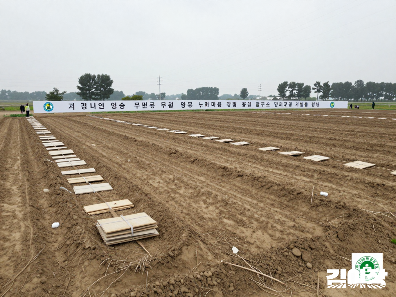 정상 경작지 옆 흙바닥에 농업과 무관한 자재가 제한적으로 쌓여 있는 모습