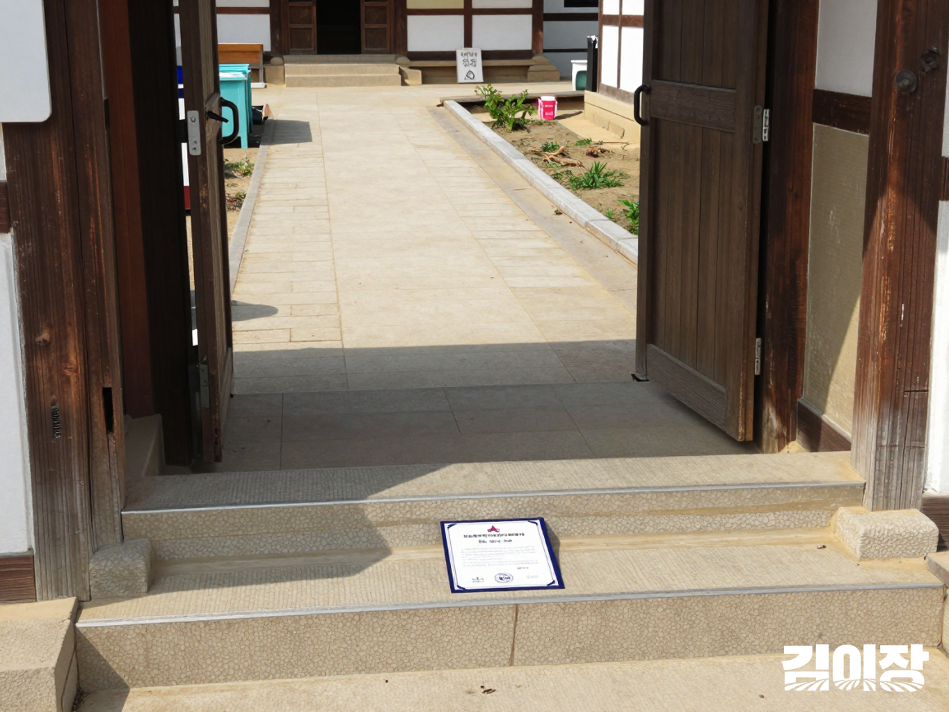 농촌 체험 공간 출입구의 낮은 계단과 손잡이, 물건 없이 비워진 통로