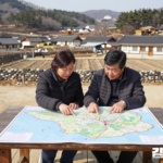 농촌 지역 지도를 펴고 관광 자원 연결을 살펴보는 귀촌 부부